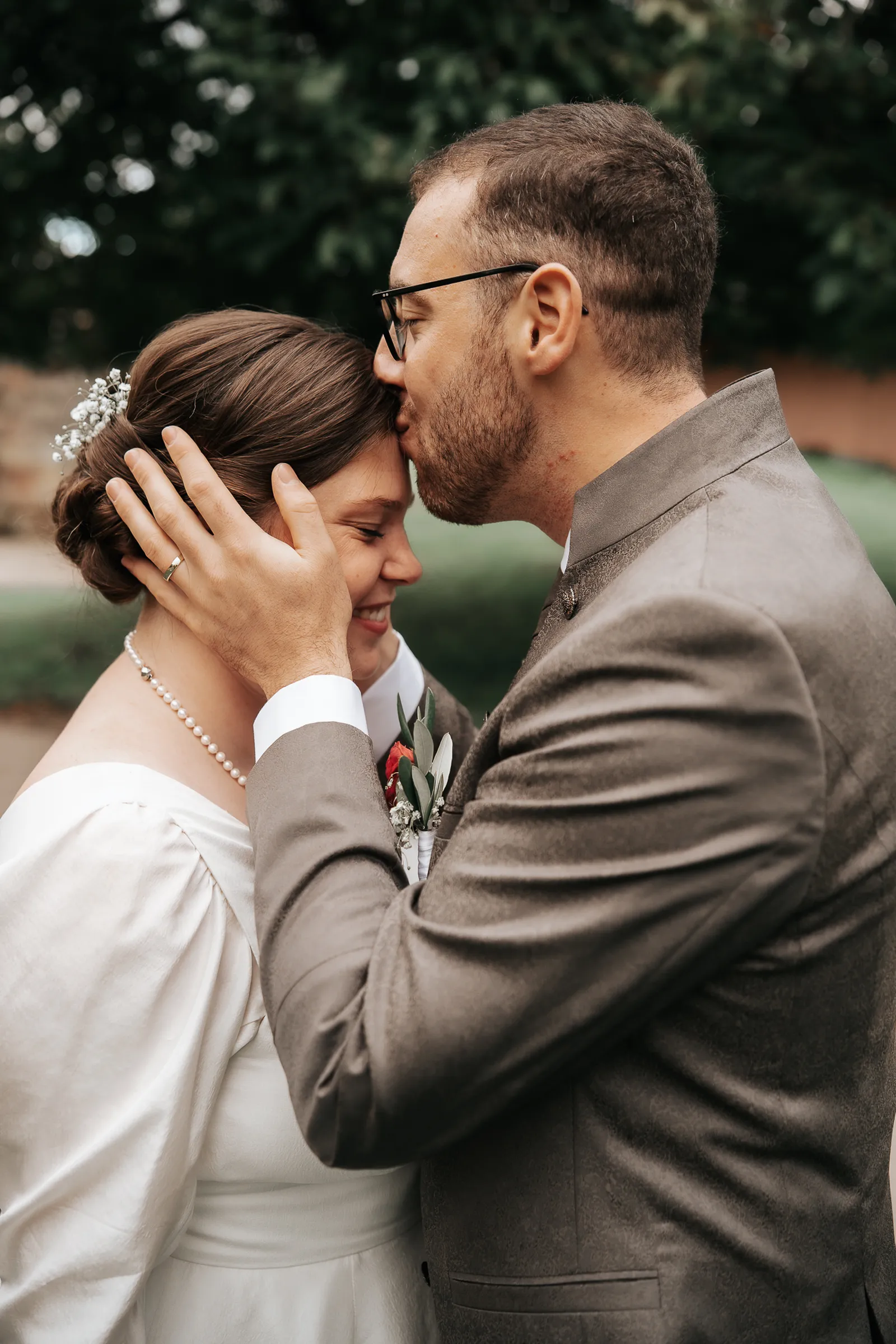 Kuss von Massimo auf die Stirn von Hélène während des Brautpaarshootings – emotionaler Moment am Linslerhof, fotografiert by SB Snaps, Hochzeitsfotograf im Saarland